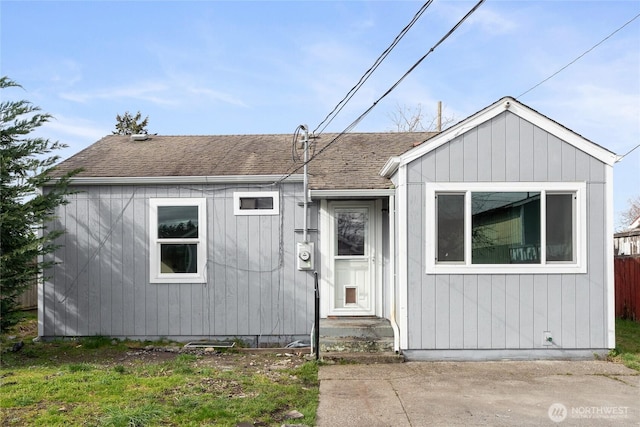 view of front of home with a shingled roof and fence