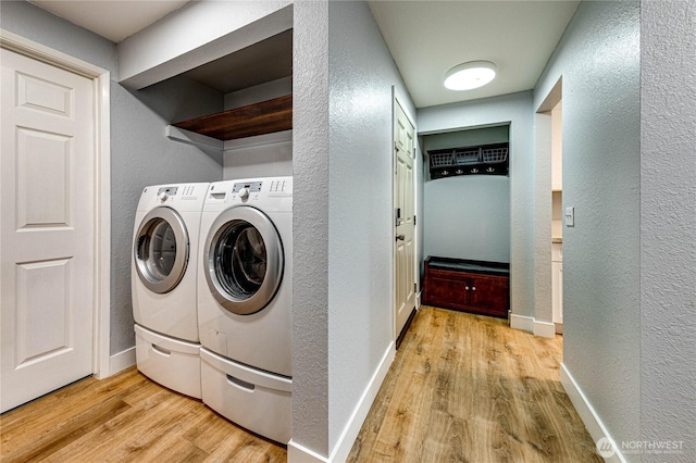 clothes washing area with laundry area, baseboards, independent washer and dryer, and light wood finished floors