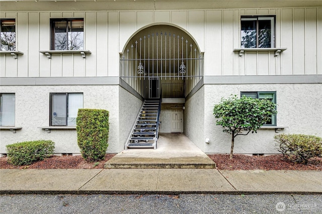 entrance to property with crawl space and stucco siding