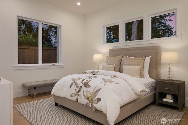 bedroom with baseboards, wood finished floors, and recessed lighting