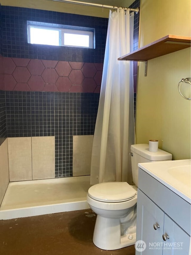 full bath featuring vanity, toilet, and a stall shower