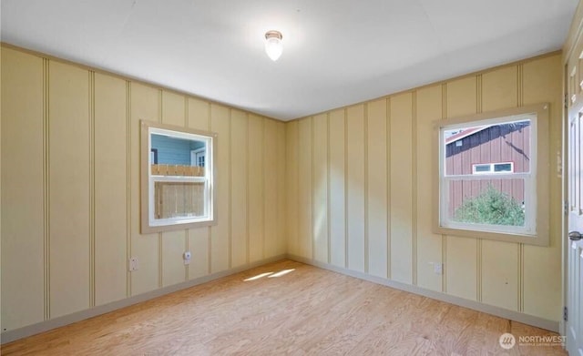 spare room with light wood-style floors and a decorative wall