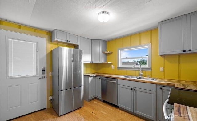 kitchen featuring a sink, stainless steel appliances, and gray cabinetry