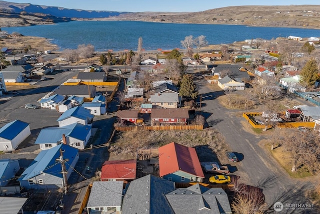 drone / aerial view featuring a residential view and a water and mountain view