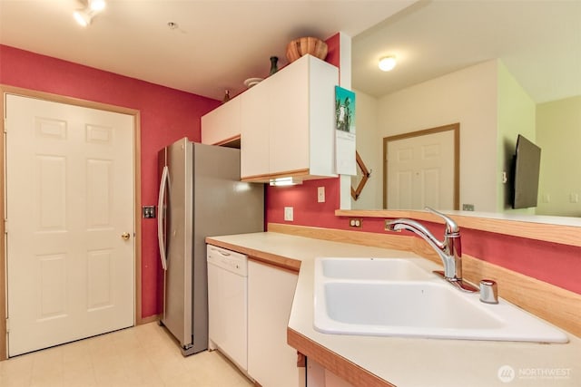 kitchen featuring light countertops, a sink, dishwasher, and white cabinetry