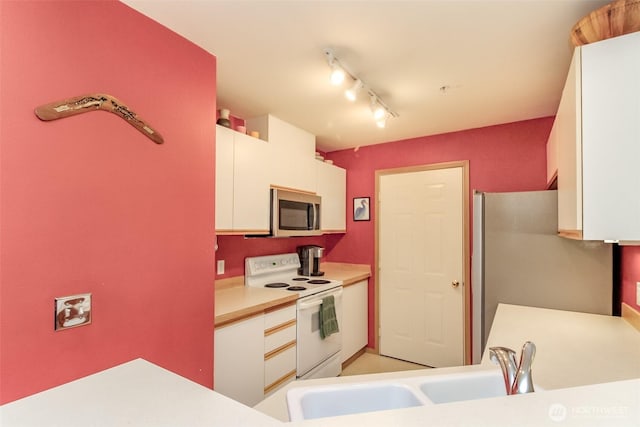 kitchen featuring white cabinetry, appliances with stainless steel finishes, light countertops, and a sink