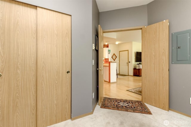 hall featuring carpet floors, electric panel, and baseboards