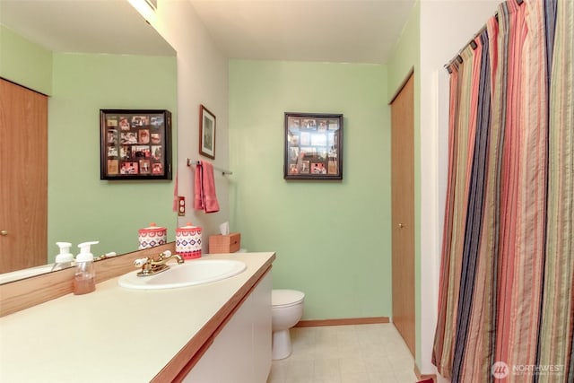 full bath with toilet, baseboards, and vanity