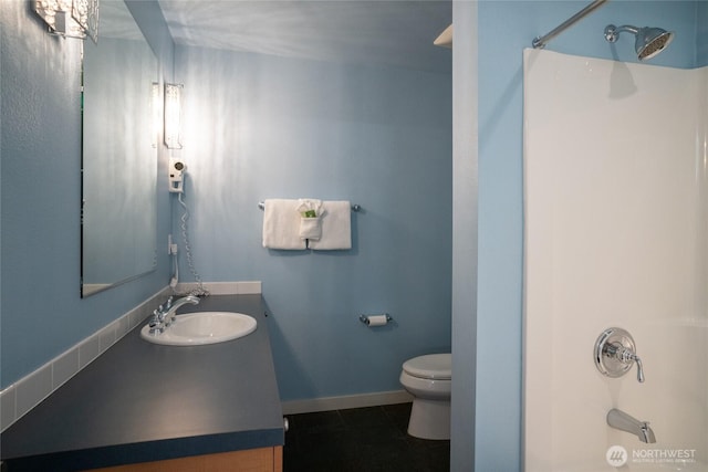 full bath featuring tile patterned flooring, shower / tub combination, toilet, vanity, and baseboards