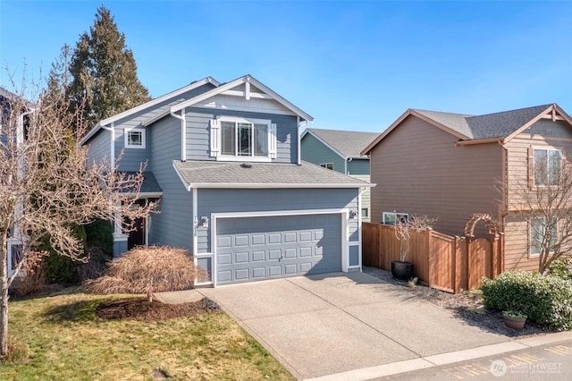 view of front of property featuring a garage, a shingled roof, driveway, and fence