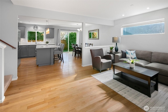 living room with light wood finished floors, stairway, recessed lighting, and baseboards