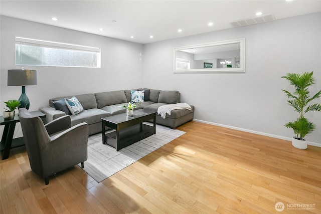 living area with recessed lighting, visible vents, light wood-type flooring, and baseboards