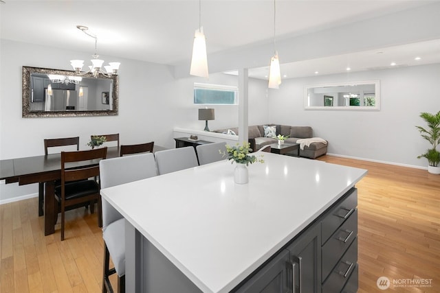 kitchen featuring light countertops, recessed lighting, light wood-style floors, hanging light fixtures, and refrigerator