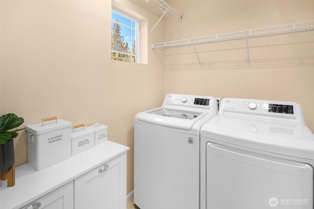 washroom with washer and dryer and cabinet space