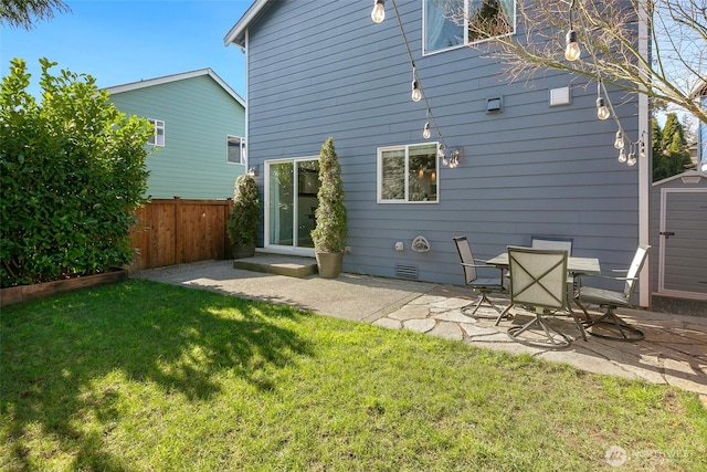 rear view of property with a yard, a patio, and fence