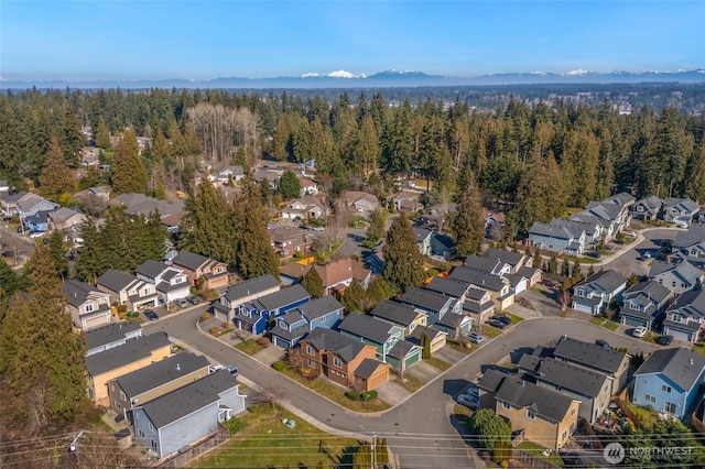 bird's eye view featuring a mountain view, a view of trees, and a residential view