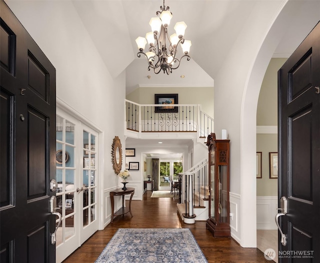 entrance foyer featuring french doors, dark wood-style flooring, wainscoting, and stairs