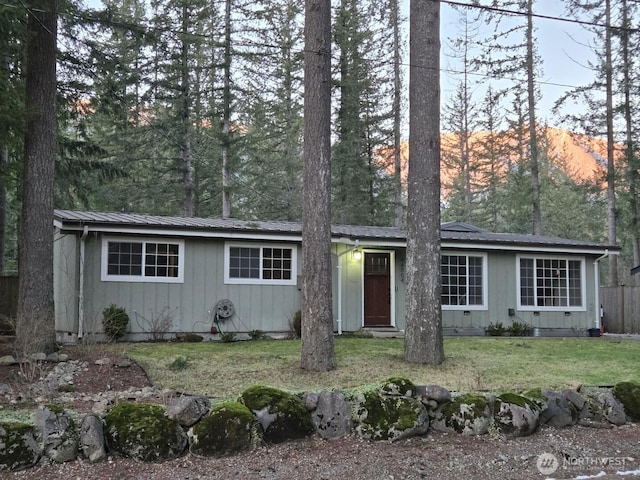 ranch-style house with a front lawn and metal roof