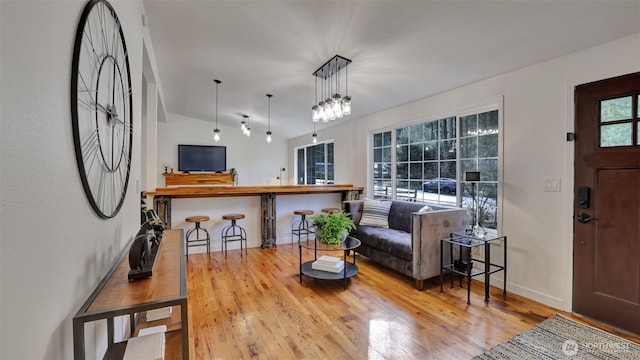 living room with baseboards, lofted ceiling, and wood finished floors