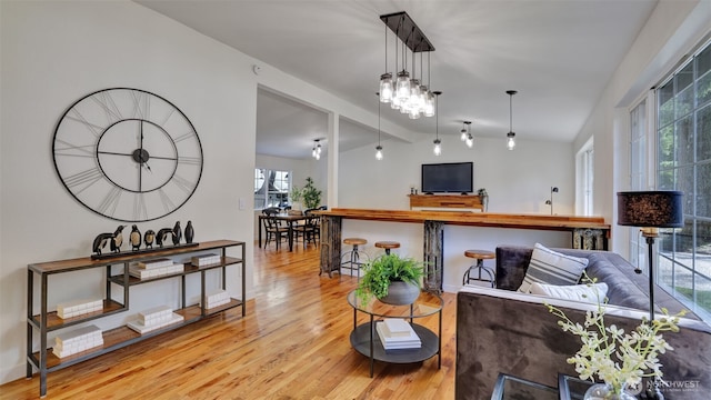 living area with wood finished floors and vaulted ceiling