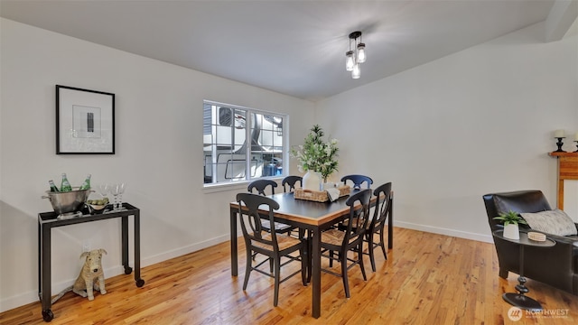 dining space with light wood finished floors and baseboards