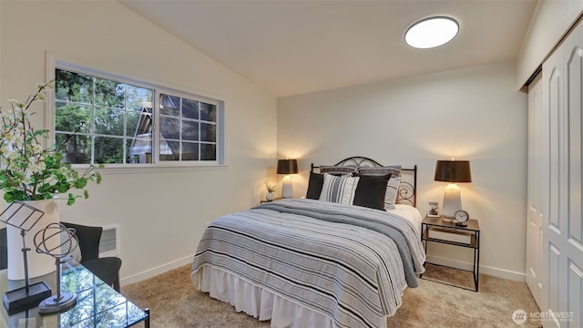 carpeted bedroom with baseboards, lofted ceiling, and a closet