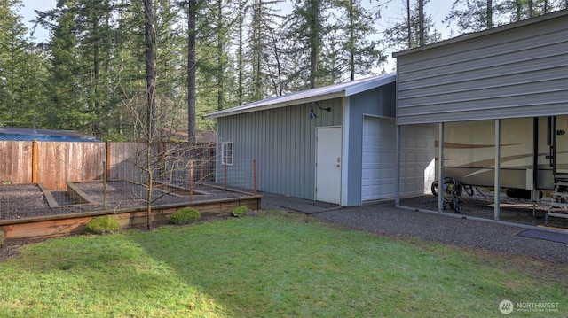 view of yard with a garden, fence, and a garage