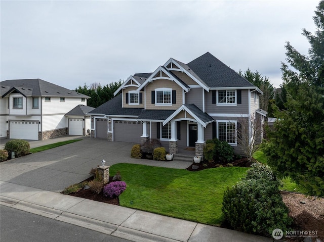 craftsman-style home featuring stone siding, driveway, roof with shingles, and a front lawn