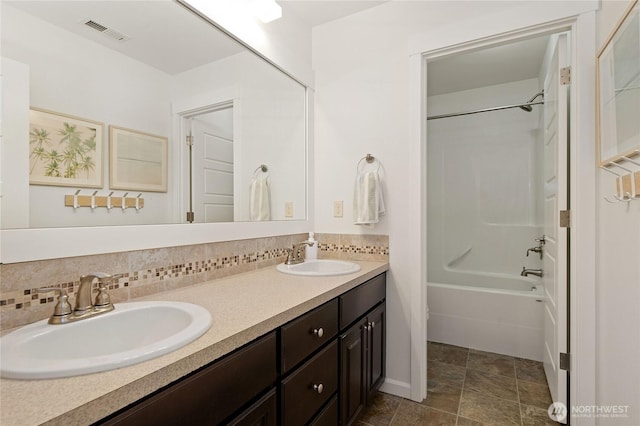 bathroom with tasteful backsplash, visible vents, double vanity, and a sink