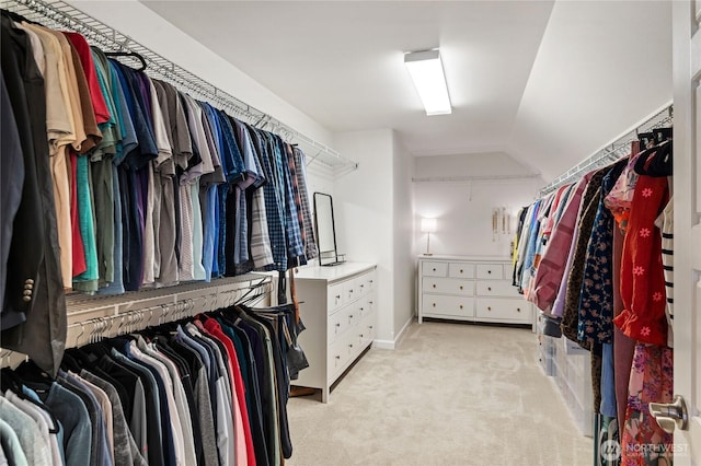 walk in closet featuring light carpet and vaulted ceiling