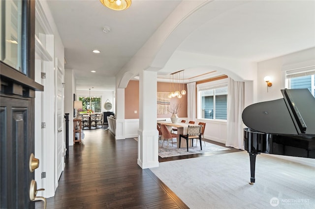 foyer with recessed lighting, arched walkways, a notable chandelier, and dark wood finished floors