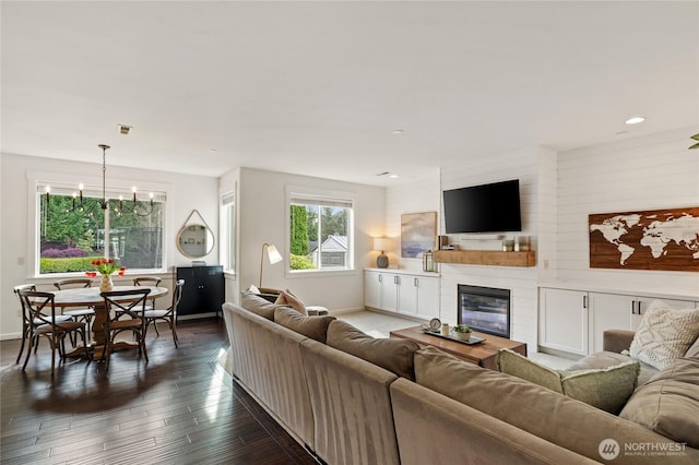 living area with baseboards, dark wood-style floors, visible vents, and a large fireplace