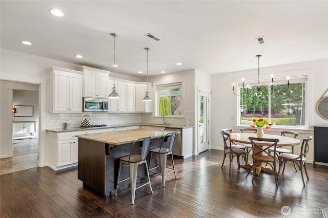 kitchen with visible vents, dark wood-style flooring, a sink, appliances with stainless steel finishes, and white cabinetry