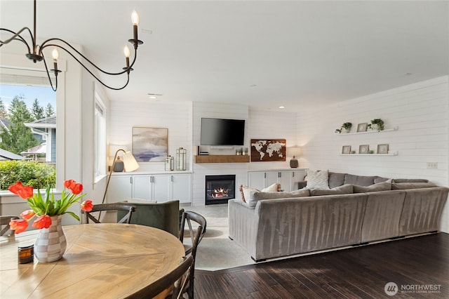 living room with dark wood-type flooring and a large fireplace