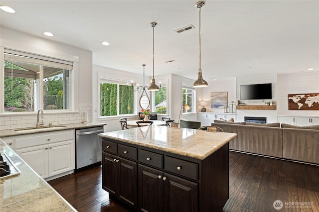 kitchen with dark wood-style flooring, white cabinets, stainless steel appliances, and a sink