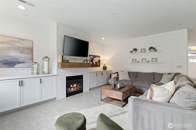 living area featuring a fireplace, recessed lighting, light colored carpet, and visible vents