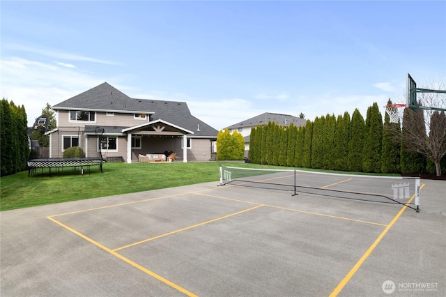 view of tennis court featuring a yard