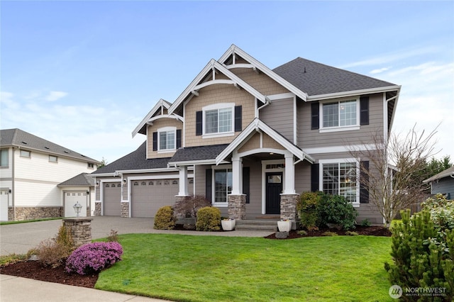 craftsman house with a front lawn, concrete driveway, a garage, and roof with shingles