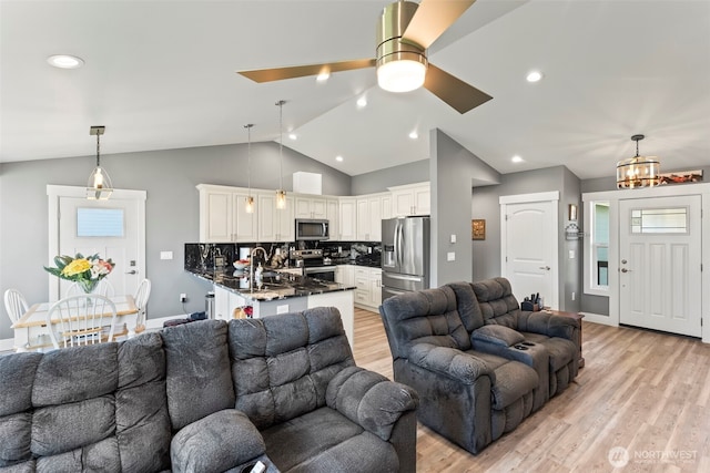 living area featuring vaulted ceiling, recessed lighting, baseboards, and light wood-style floors