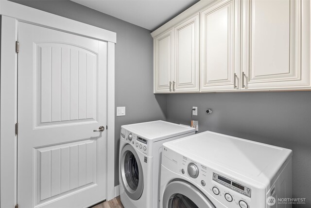 clothes washing area featuring cabinet space and washer and dryer