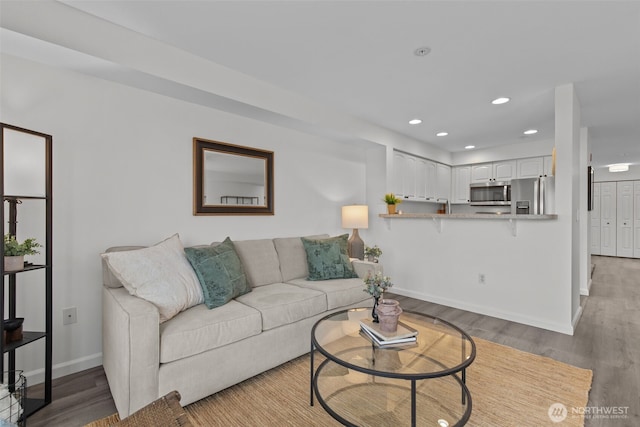 living area with recessed lighting, light wood-type flooring, and baseboards