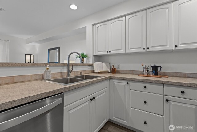 kitchen with stainless steel dishwasher, recessed lighting, white cabinetry, and a sink