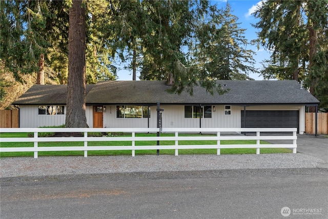 ranch-style house featuring a fenced front yard and a garage