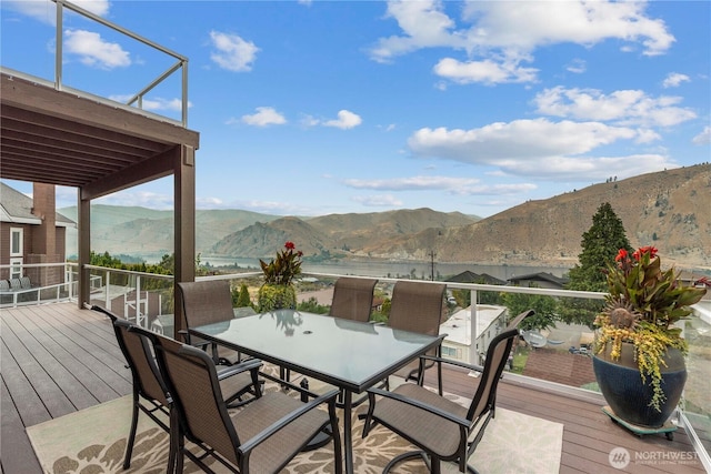 wooden deck featuring a mountain view and outdoor dining space