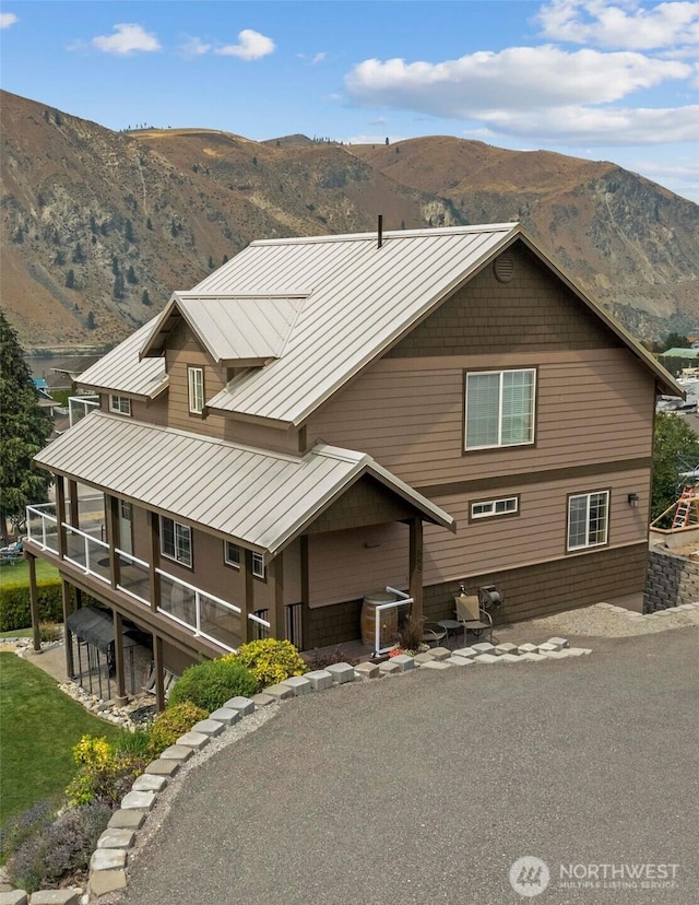 view of front of house with a standing seam roof, a mountain view, and metal roof