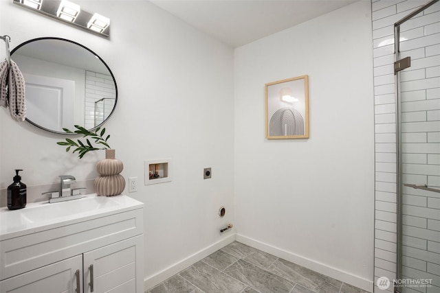 laundry room featuring baseboards, cabinet space, a sink, washer hookup, and electric dryer hookup