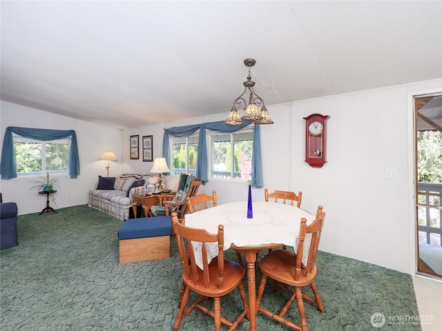 carpeted dining area featuring plenty of natural light and an inviting chandelier