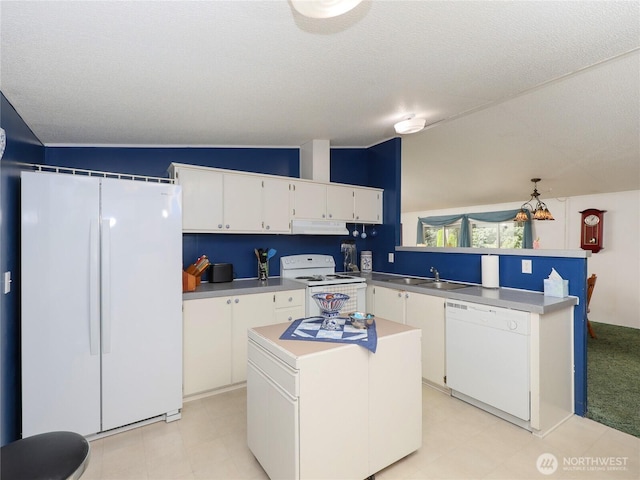 kitchen featuring a center island, lofted ceiling, white cabinetry, white appliances, and a peninsula