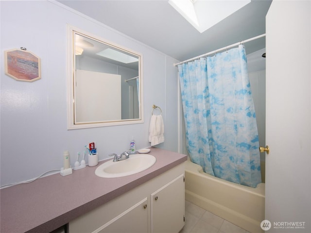 bathroom featuring a skylight, tile patterned flooring, vanity, and shower / bathtub combination with curtain