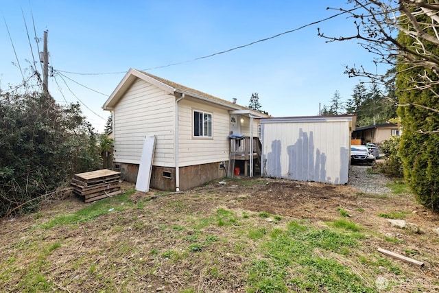 back of property with an outbuilding and a storage shed